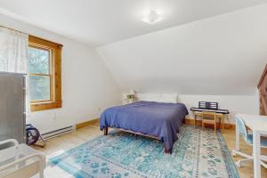 a bedroom with a bed and a table and a window at Turner Hill Cottage in West Townshend