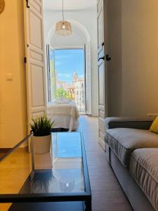 een woonkamer met een bank en een glazen tafel bij Apartamentos Alcazaba in Málaga