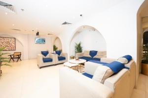 a living room with white furniture and blue pillows at فندق ديمورا Dimora Hotel in Makkah