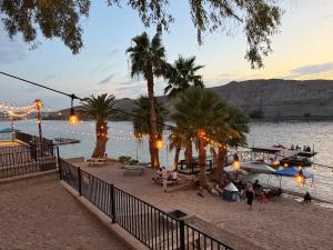 a beach with palm trees and a boat in the water at Couples getaway in Bullhead City