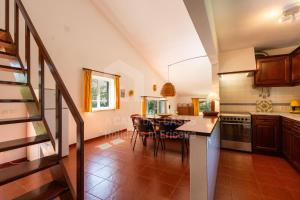 una cucina con un tavolo e sedie in una stanza di Casa Lantana by ACasaDasCasas a Casas Velhas