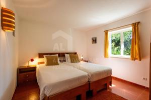 una camera da letto con un letto e una finestra di Casa Lantana by ACasaDasCasas a Casas Velhas