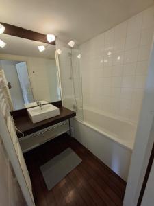 un bagno con un lavandino, uno specchio e una vasca di cottage Le Vau15 a Chaveignes