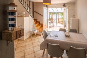 a dining room with a table and chairs and a staircase at La Canotière in Saint-Georges-dʼOléron