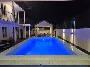 a swimming pool in the middle of a building at night at Ivy's Place in Paramaribo