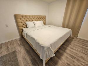 a bedroom with a large bed with white sheets at Ivy's Place in Paramaribo +8 photos