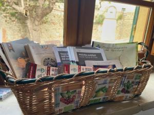 a basket full of books sitting on a window sill at Le Giuggiole in Tuscany in Usigliano