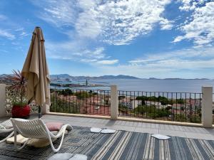 a patio with an umbrella and a chair and a table at Superbe terrasse avec vue panoramique sur la mer in Marseille