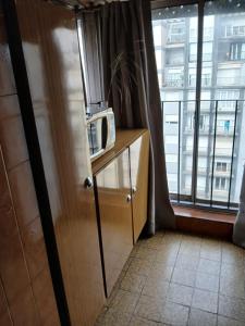 a kitchen with a microwave on a counter next to a window at carmon colon 1 ambiente y medio in Mar del Plata +14 photos