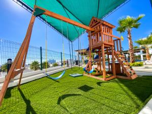 a playground with a swing and a swing at Índigo 7, Steps from Playa Brujas Beach in Mazatlán