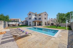 a villa with a swimming pool and a house at Villa Cangarela in Višnjan