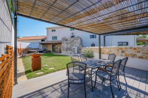a patio with a table and chairs on a deck at Villa Cangarela in Višnjan