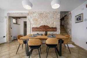 a dining room with a wooden table and chairs at Villa Cangarela in Višnjan