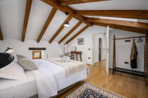a bedroom with a large white bed and wooden ceilings at Villa Cangarela in Višnjan +42 photos