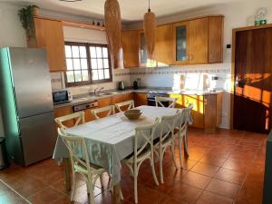 eine Küche mit einem Tisch mit Stühlen und einem Kühlschrank in der Unterkunft First-Line Oceanfront House in Moledo in Moledo