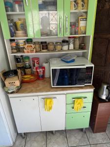 a kitchen with green cabinets and a microwave on a counter at Casa del Pasaje in Trujillo
