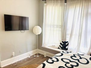 a bedroom with a bed and a flat screen tv at Chic & Cozy Studio Retreat in Memphis