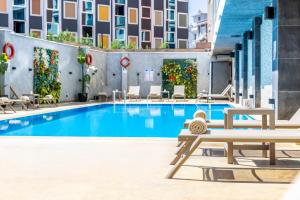 a pool at a hotel with benches and chairs at Ramada Plaza By Wyndham Istanbul Sultanahmet in Istanbul