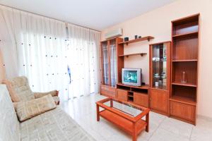 sala de estar con sofá y TV en Roura Planet Costa Dorada, en La Pineda