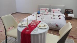 a table with wine glasses on it next to a bed at وطن in Hafr Al-Batin +8 photos