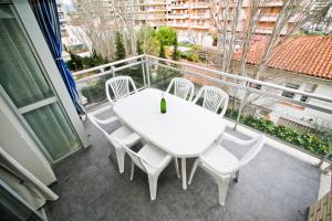 - Balcón con mesa blanca y sillas en Roura Planet Costa Dorada, en La Pineda