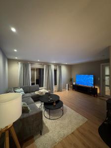 a living room with a couch and a flat screen tv at Lofoten-City Center-New apartment-Near the airport in Leknes