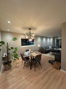 a living room with a table and chairs and a couch at Lofoten-City Center-New apartment-Near the airport in Leknes