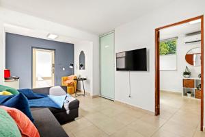 a living room with a couch and a tv on a wall at Cacique Vacation Rental by Otium in San Juan