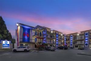 a parking lot with cars parked in front of a building at Best Western Courtesy Hotel - Anaheim Resort Amusement Park in Anaheim