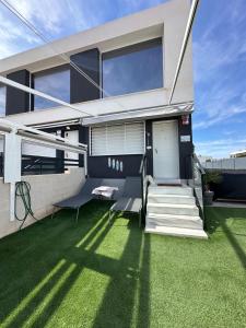 a house with a green lawn in front of it at Beach House Renata in Gran Alacant