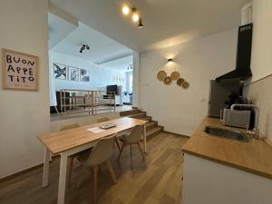 a kitchen and dining room with a wooden table and chairs at Apartamentos Matilda Conil - Playa in Conil de la Frontera