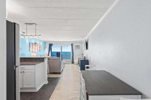 a kitchen and living room with a view of the ocean at Salty Sands 302 in Ocean City