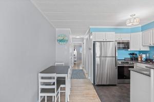 a kitchen with white cabinets and a white refrigerator at Salty Sands 302 in Ocean City