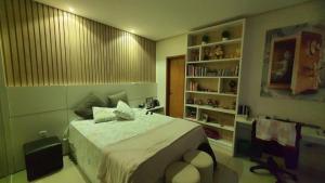 a bedroom with a bed and a book shelf at Condomínio Lion Ville in Benjamim