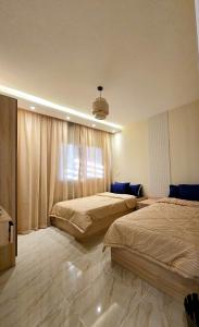 a bedroom with two beds and a window at B15/87/51 · Madinaty B15 Brand new 3BR Apt in Madinaty