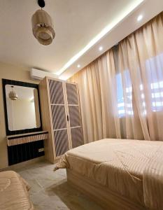 a bedroom with a bed and a mirror and a television at B15/87/51 · Madinaty B15 Brand new 3BR Apt in Madinaty