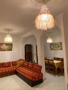 a living room with a couch and a chandelier at 5minutes walk to beach apartement- MARTIL - Appartement à 5min à pied de la plage in Martil