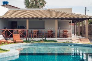 a villa with a swimming pool in front of a house at Môzzi Barra Grande in Barra Grande