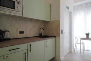 a kitchen with a sink and a microwave at CH Plaza Elíptica 1 in Madrid