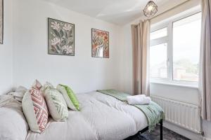 a bedroom with a bed with pillows and a window at 3 Bedroom Property, Free Parking for 3 Vehicles in Mile End