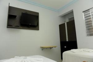 a room with two beds and a tv on the wall at Gran Fortaleza Hotel in Goiânia