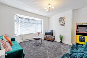 a living room with a green couch and a tv at 3 Bedroom Property, Free Parking for 3 Vehicles in Mile End