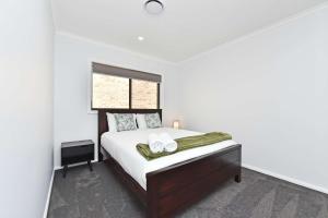 a white bedroom with a bed with two towels on it at Huntlee Heights in North Rothbury +12 photos