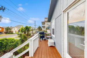 a porch of a white house with a table and chairs at Entire House - Serenity in Surf City in Surf City