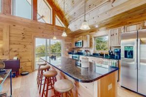 Cabaña de madera con cocina con encimera grande y taburetes en Nanuk, en Needmore 19 fotos más
