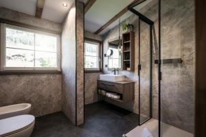 ein Badezimmer mit Dusche, Toilette und Waschbecken in der Unterkunft Alpstay - Hotel Acadia - Adults Mountain Home in Wolkenstein in Gröden