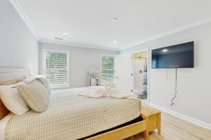 a bedroom with a bed with a tv on the wall at Pawleys PARadise in Pawleys Island