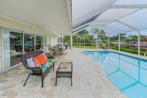 une piscine avec un canapé et une table à côté d'une piscine dans l'établissement Beautiful electric-heated pool home on Sailboat Access Canal - Villa Francis, à Cape Coral