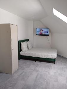 Habitación con sofá y TV en la pared. en Joli T1 bis rénové, en Lille
