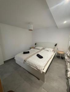 a bedroom with a large bed with two black towels on it at Le Rossignol in Collonges-sous-Salève